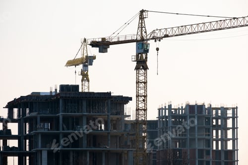 Preview: Tower cranes and high residential apartment buildings under construction. Real estate development.