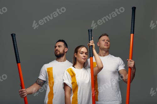 Preview: People stand together and practice sticks. Karate masters posing with sticks in the studio together.