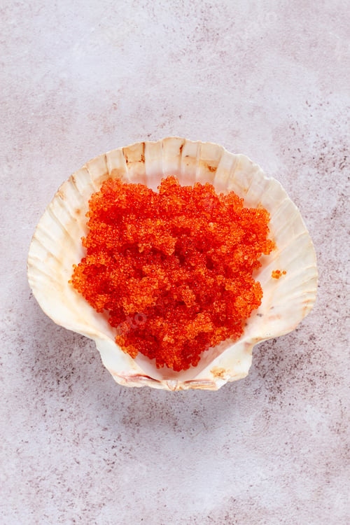 Preview: orange flying fish roe, Tobiko roe, in a seashell, top view,