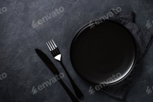 Preview: Black plate, cutlery and napkin on stone table top view
