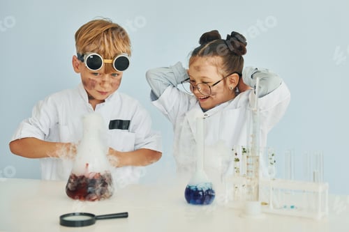 Preview: Girl with boy working together. Children in white coats plays a scientists in lab by using equipment