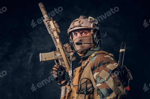 Preview: Elite unit, special forces soldier in camouflage uniform posing with assault rifle.