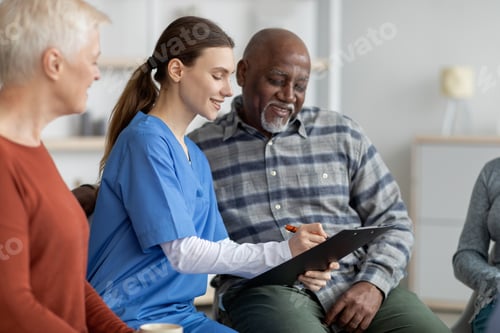 Preview: Supportive nursing home attendant helping senior black man filling papers