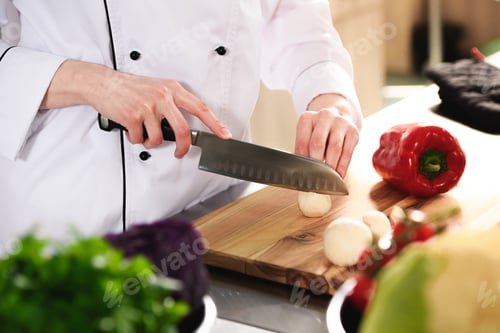 Preview: Close-up view of female chef cutting mushrooms on wooden board