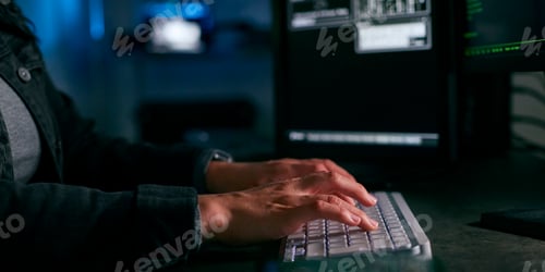 Preview: Close Up On Hands Of Female Computer Hacker Sitting In Front Of Screens Breaching Cyber Security