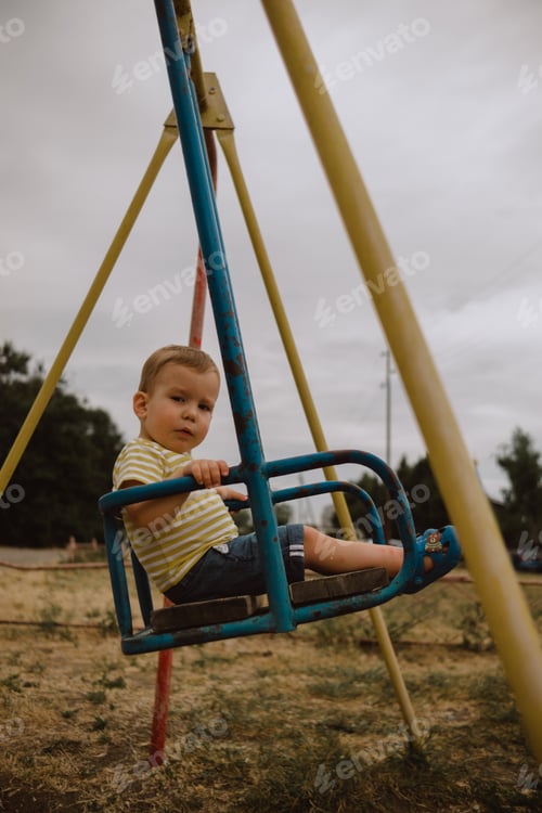 Preview: a child swings on a swing in summer