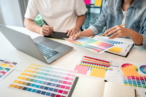 Preview: Two creative graphic designer team working on color selection and drawing on graphic tablet
