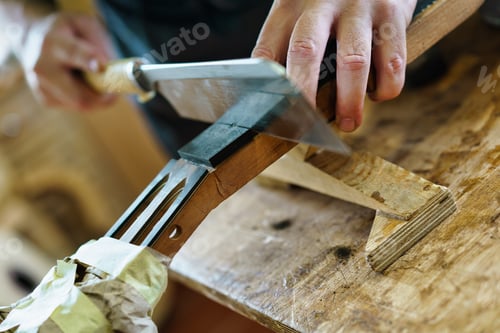 Preview: Unrecognizable luthier cutting guitar neck marking the frets