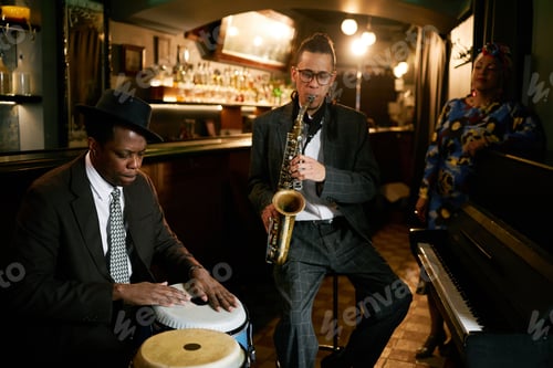 Preview: Male Conga Drummer And Saxophonist Playing Instruments in Jazz Club
