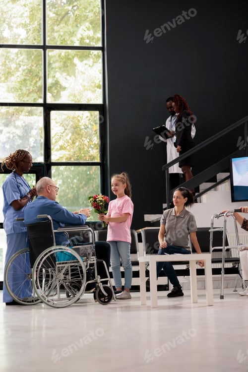 Preview: Granddaughter giving bouquet of flowers to disabled grandfather during checkup visit appointment