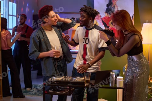 Preview: Group of young Friends Socializing and Laughing at House Party