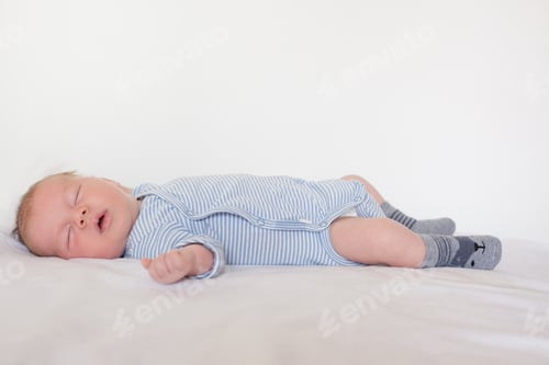 Preview: Cute Baby Sleeping Peacefully on a White Blanket