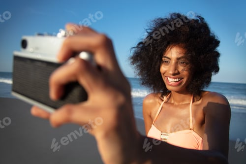 Preview: Afro girl taking selfie on beach with camera