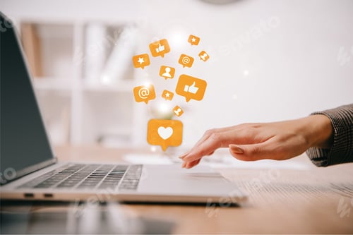 Preview: cropped view of businesswoman typing on laptop at workplace with multimedia icons