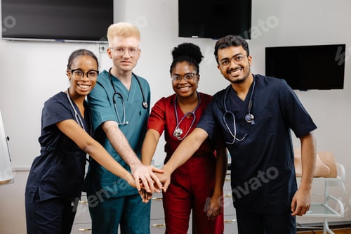 Preview: Medical team joining hands in hospital room