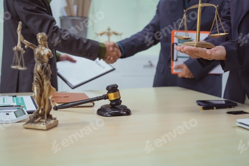 Preview: Three lawyers in a meeting at the table in an office, shaking hands discussing business, focusing