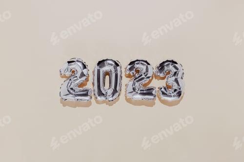 Preview: Christmas or New Year background. Beige flat lay, silver 2023 baloon numbers