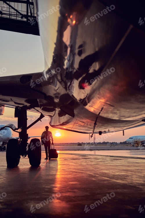 Preview: View of part airplane standing in the aviation hangar isolated on sunset background