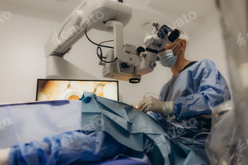 Preview: A surgeon looks through a microscope in the operating room. A doctor uses a microscope during eye
