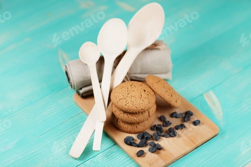 Preview: Composition of tasty biscuits and raisins over vintage wooden table.
