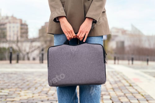 Preview: hands of an unrecognizable woman holding briefcase