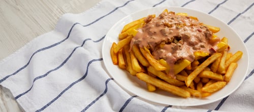 Preview: Homemade Animal Style French Fries on a white plate, low angle view. Copy space.