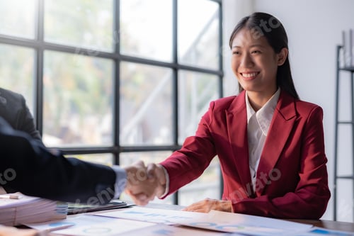 Preview: Young Asian businesswoman handshake to congratulate success.