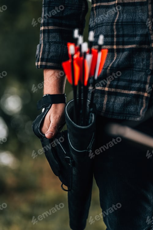 Preview: Young man stands outdoors, with a quiver of arrows and bow slung across his back