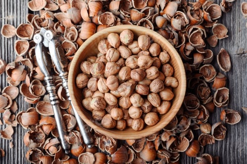 Preview: Top view on wooden plate with hazelnuts kernels
