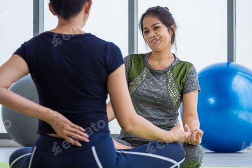 Preview: Two asian women doing yoga together at a gym.