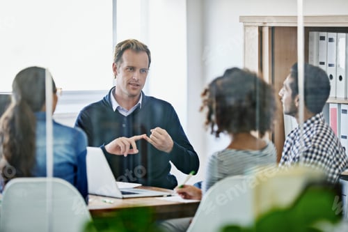 Preview: Assigning tasks. Cropped shot of four young designers having a business meeting.