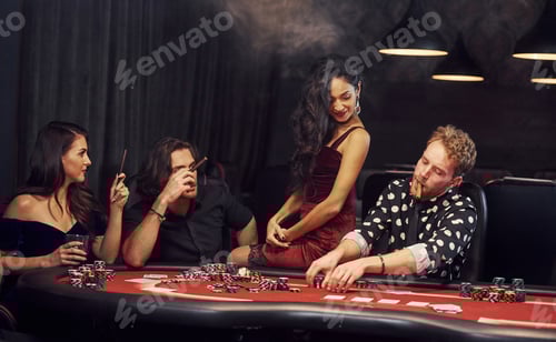 Preview: Group of elegant young people that playing poker in casino together