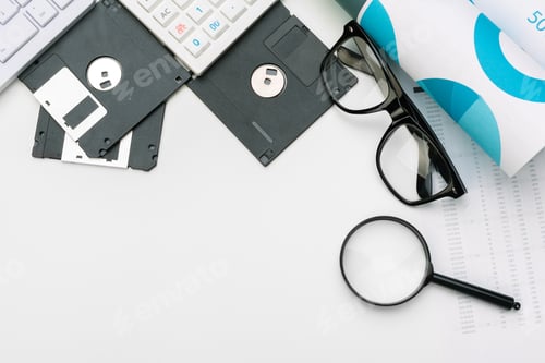 Preview: magnifying glass inspecting on floppy disk concept