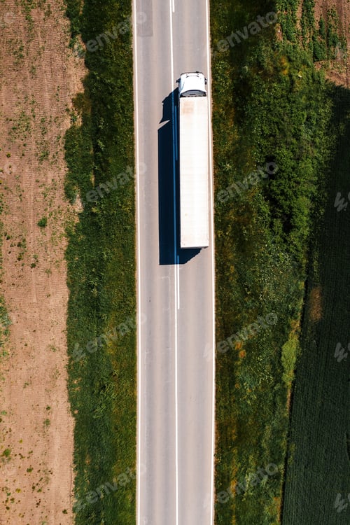 Preview: Aerial shot of semi-truck driving along the highway through countryside landscape, drone pov
