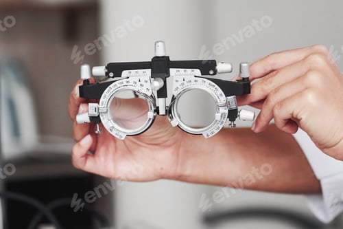 Preview: Focused photo. Female hands holding the optical device for eye testing