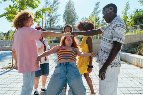 Preview: Multiethnic group of young friends meeting and having fun outdoors
