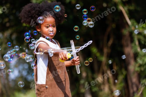 Preview: Little African American girl playing bubble at outdoor.