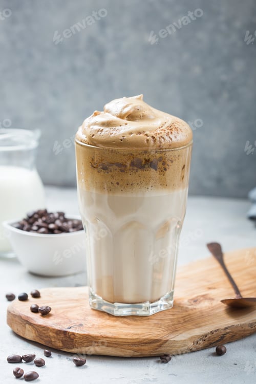 Preview: Dalgona frothy coffee in glass on grey. Trend korean drink latte with foam of instant coffee.
