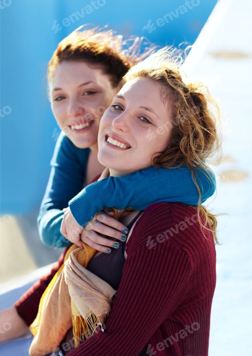Preview: Best friends and sisters. Portrait of two sisters sitting outside and embracing warmly.