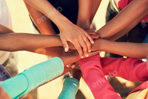 Preview: All for one. Cropped shot of a group of children standing with their hands in a huddle outside.
