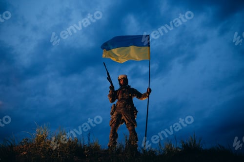Preview: An evening portrait of Ukrainian soldier with rifle and natioal flag