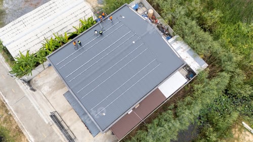 Preview: Workers install solar panels on a rooftop in a suburban neighborhood during the daytime