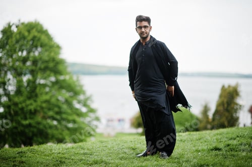 Preview: Pakistano bangladesh man wear black traditional clothes and eyeglasses pose outdoor.