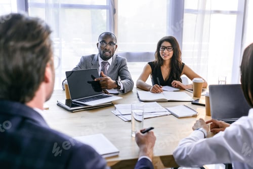 Preview: selective focus of group of multiethnic business colleagues discussing strategy during business