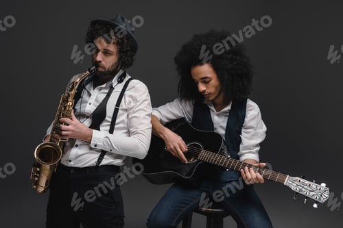 Preview: duet of musicians playing sax and acoustic guitar on black