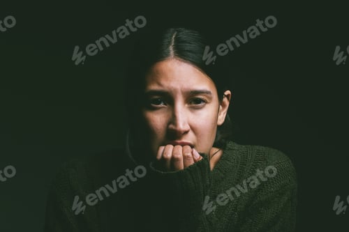 Preview: Shot of a young woman looking nervous against a dark background