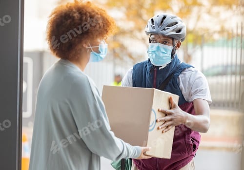 Preview: Black man, mask and delivery with box for woman at house for logistics, cargo and safety from covid