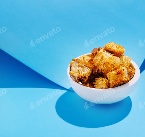 Preview: Crunchy croutons in a white bowl against a blue background