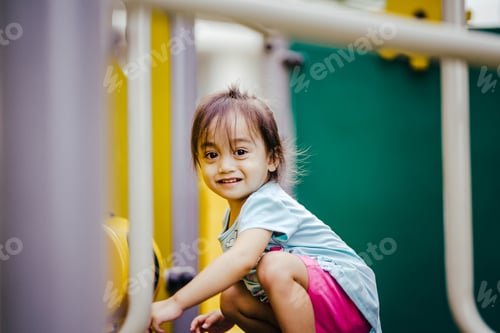 Preview: Toddler squatting and smiling at the playground.