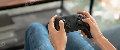 Preview: Close up of hand holding joysticks with playing online game.